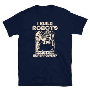 May include: Navy blue t-shirt featuring a robot graphic and the text "I build robots. What's your superpower?"