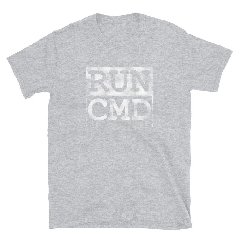 K&ouml;nnte beinhalten: Ein hellgraues T-Shirt mit kurzen &Auml;rmeln und einem wei&szlig;en Aufdruck mit der Aufschrift "RUN CMD" in einer verwitterten Schriftart.