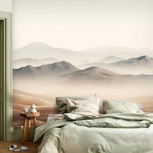 May include: A bedroom with a mountain landscape mural. The room features a bed with light green bedding, a small wooden side table, and open green doors. The mural depicts a desert mountain range with a hazy atmosphere.