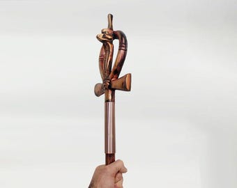 May include: A wooden Ankh staff with a copper finish. The Ankh is a symbol of life in ancient Egyptian mythology. The staff is decorated with a coiled snake design.