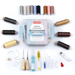May include: Leather sewing kit with 10 leather stitching needles, 3 leather sewing needles, 1 stitching awl, 1 thread thimble, 1 measuring tape, 1 pair scissors, and 1 pair of palm thimbles. The kit also includes a variety of colored threads in a clear plastic container. The container has the text "incraftables designed in the USA leather sewing kit" on the front.