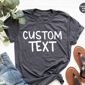May include: A heather dark grey t-shirt with the text "CUSTOM TEXT" printed in white on the front.