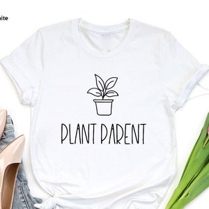 May include: White t-shirt with a black line drawing of a potted plant and the text "Plant Parent" printed on the front.