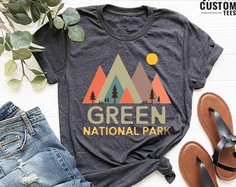 May include: A dark gray t-shirt with a graphic of colorful mountains and trees. The text "GREEN NATIONAL PARK" is printed below the graphic.