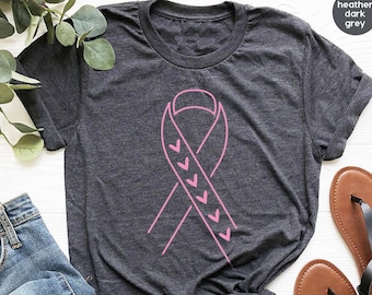 Peut inclure: Un t-shirt gris foncé chiné avec un motif de ruban rose. Le ruban est orné d'une série de petits cœurs roses sur les bords.