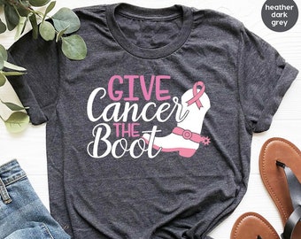 May include: Heather dark grey t-shirt with the text "Give Cancer the Boot" and a pink cowboy boot with a pink ribbon.