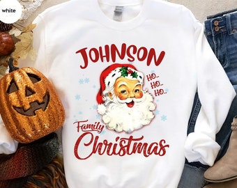 May include: White Christmas sweatshirt with a red and white illustration of Santa Claus and the text "JOHNSON Family Christmas" in red.