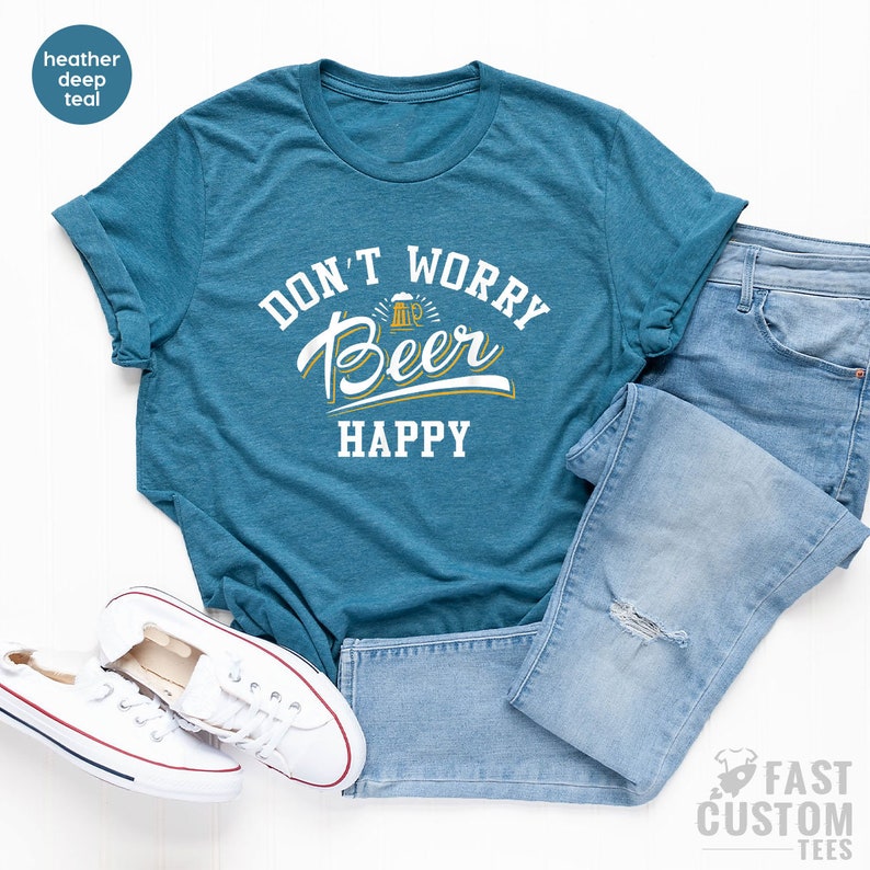 May include: A teal blue t-shirt with the text "Don't Worry Beer Happy" in white with a yellow beer mug graphic.