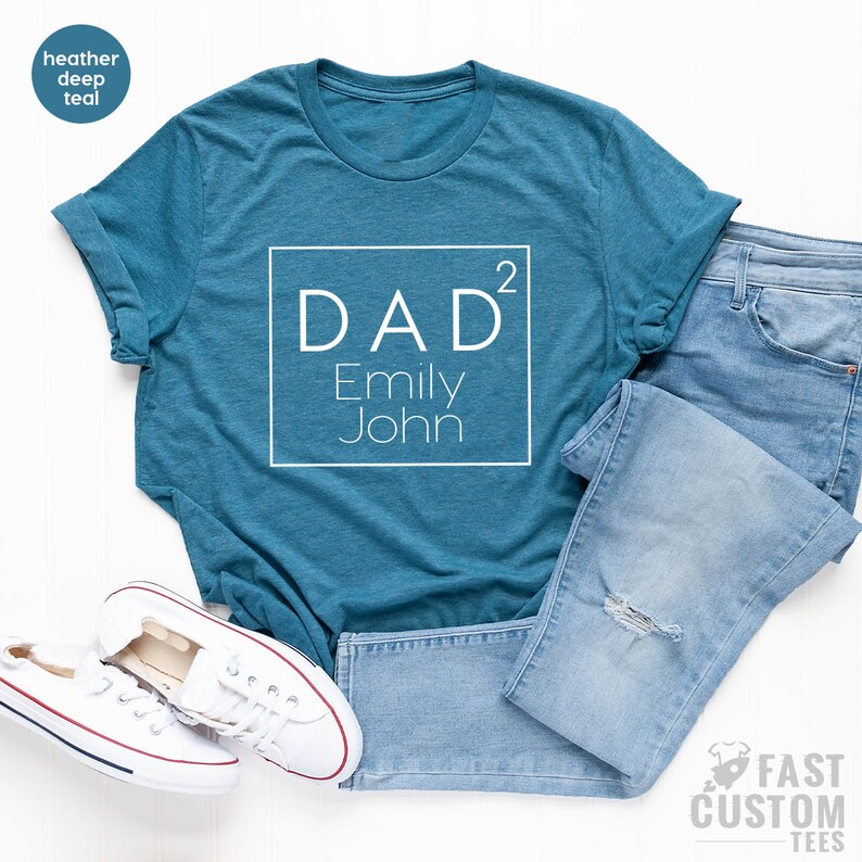 May include: A teal blue t-shirt with a white square graphic that says "DAD&sup2; Emily John" on it.