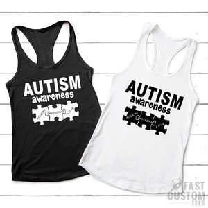 May include: Two tank tops with the text "AUTISM awareness" and a puzzle piece with the words "ACCEPT, UNDERSTAND, LOVE" printed on them. The tank tops are black and white.