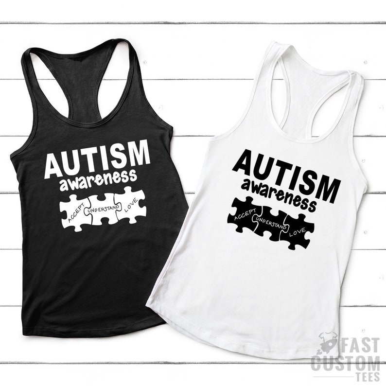 May include: Two tank tops with the text "AUTISM awareness" and a puzzle piece with the words "ACCEPT, UNDERSTAND, LOVE" printed on them. The tank tops are black and white.