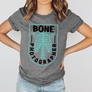 a woman wearing a t - shirt with a skeleton on it