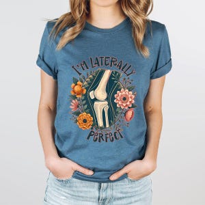 a woman wearing a blue t - shirt that says i'm materially perfect