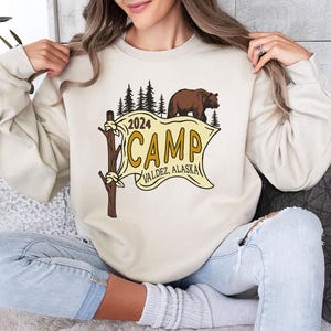 a woman sitting on a couch holding a sweatshirt