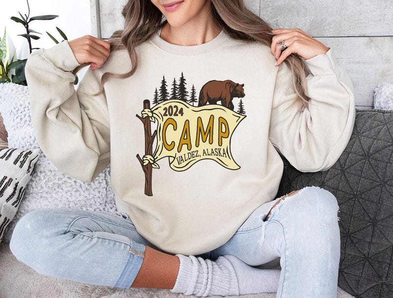 a woman sitting on a couch holding a sweatshirt