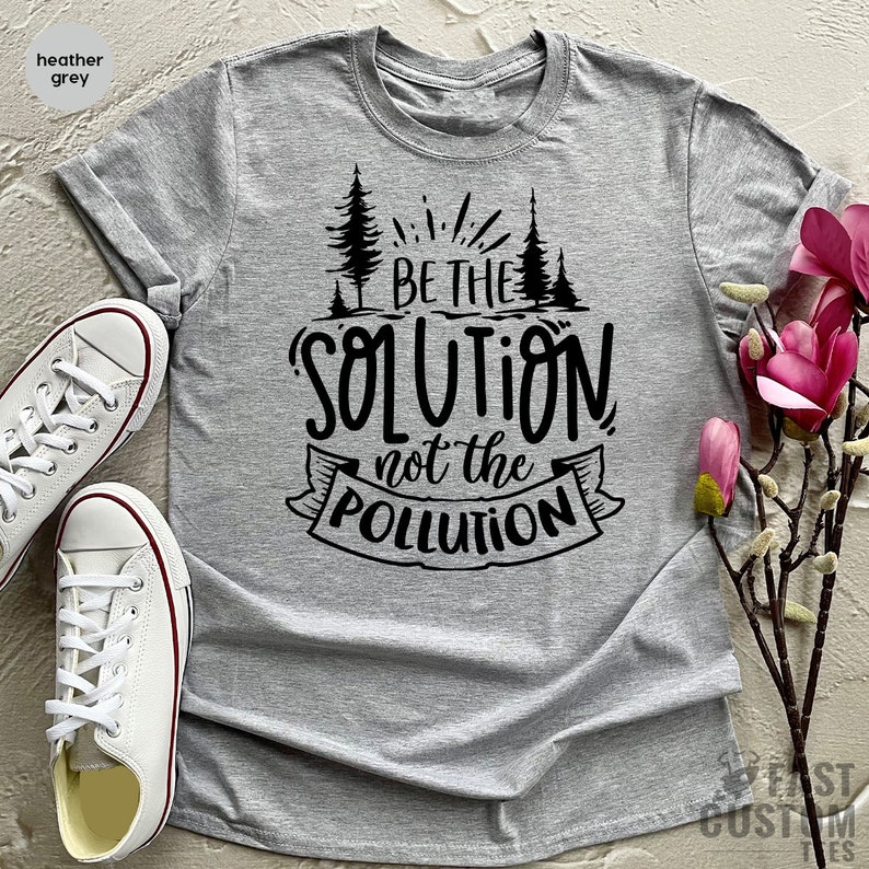 May include: Heather grey t-shirt with a black graphic that reads "Be the solution not the pollution". The graphic features a stylized tree design.