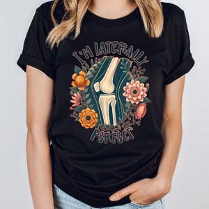 a woman wearing a black t - shirt with a picture of a woman's