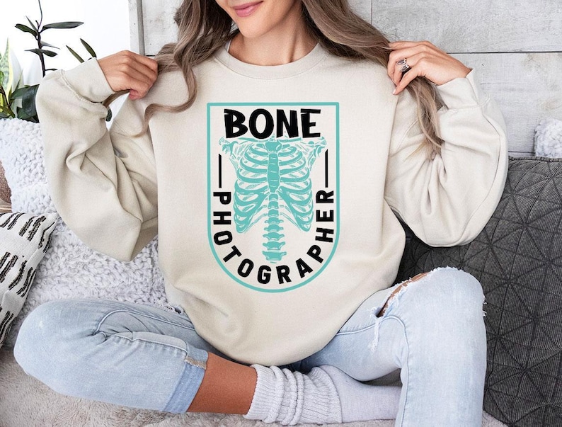a woman sitting on a couch wearing a sweater with a skeleton on it