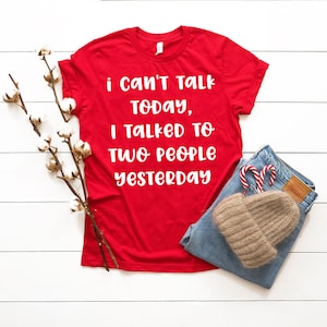 May include: Red t-shirt with white text that reads "i can't talk today, i talked to two people yesterday".