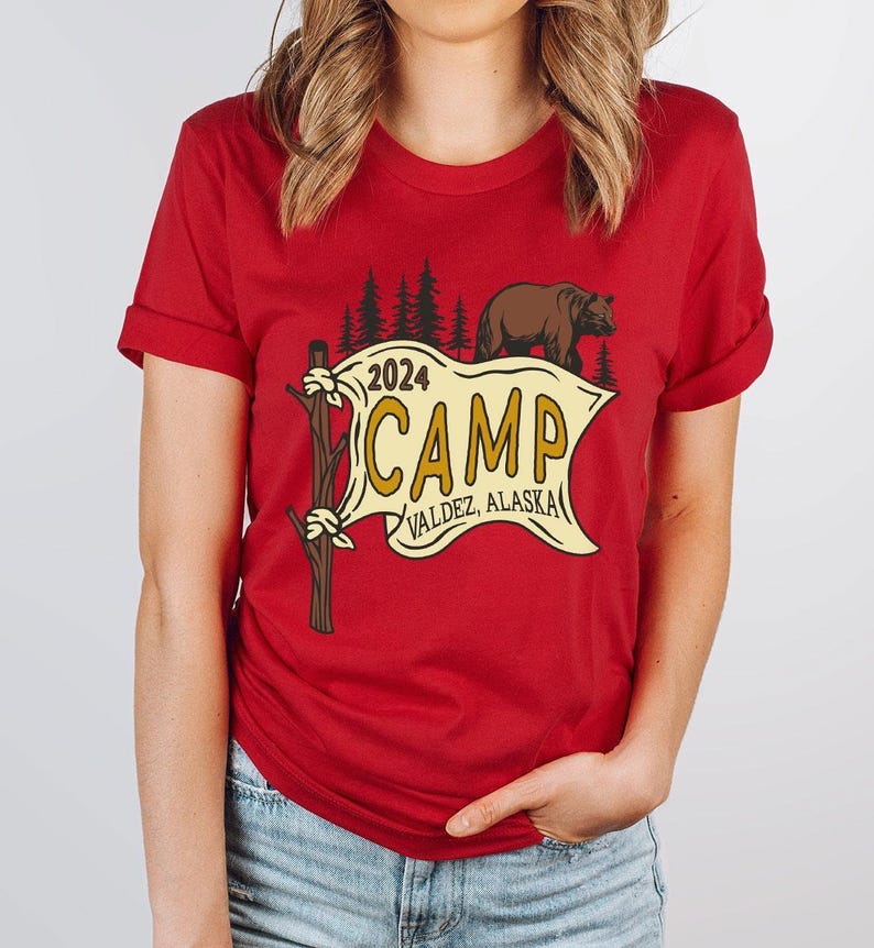 a woman wearing a red shirt with a camp sign on it