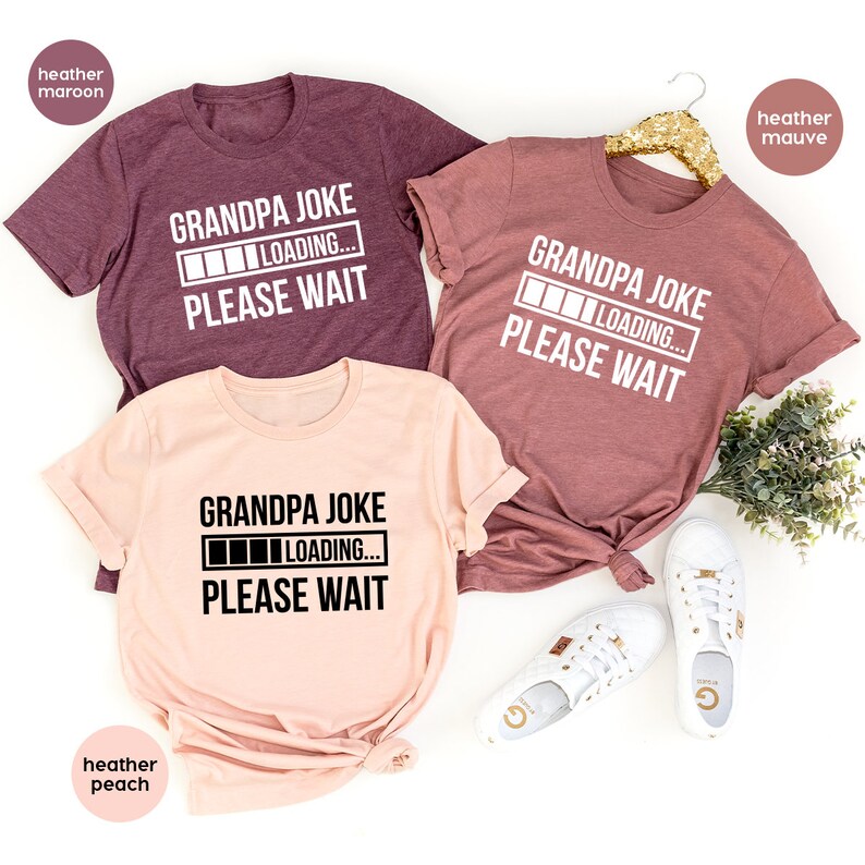May include: Three t-shirts in different colors with the text "Grandpa Joke" and a progress bar that says "Loading... Please Wait".