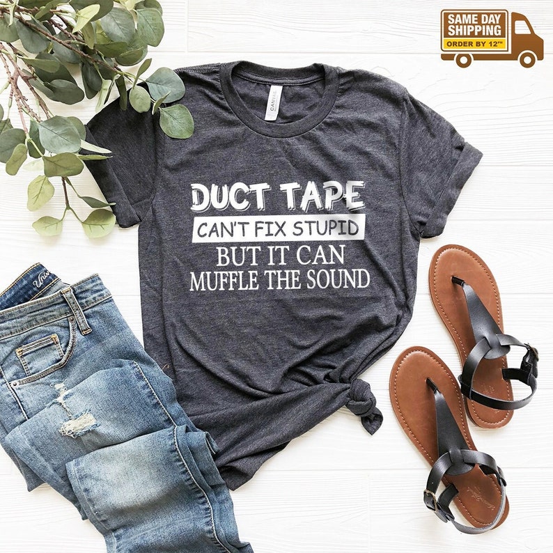 May include: A dark heather gray t-shirt with a white graphic that reads "DUCT TAPE CAN'T FIX STUPID BUT IT CAN MUFFLE THE SOUND".