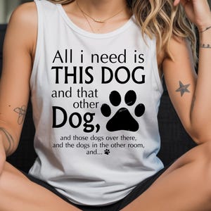 A woman wearing a white tank top with a humorous text printed on it.