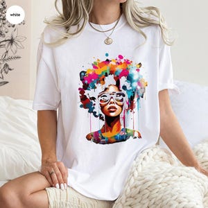a woman sitting on a bed wearing a t - shirt with a picture of a