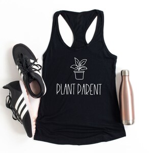 May include: Black tank top with a white outline of a potted plant and the text "PLANT PARENT".