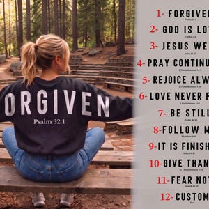 May include: A woman wearing a black sweatshirt with the word "FORGIVEN" in large white letters and "Psalm 32:1" underneath. The image also includes a design chart with inspirational phrases like "God is Love" and "Fear Not".