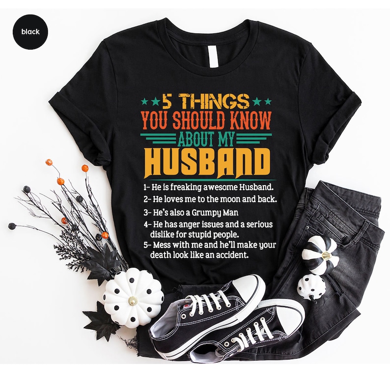 May include: Black t-shirt with a white and orange graphic that says "5 Things You Should Know About My Husband" with a list of five humorous reasons why.