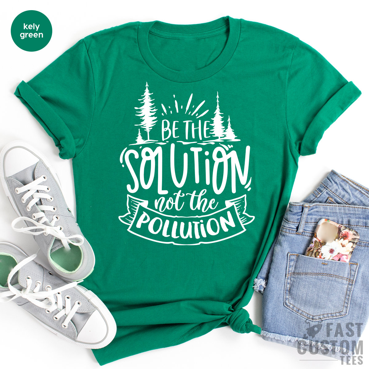 May include: A kelly green t-shirt with white text that reads "Be the Solution not the Pollution". The text is surrounded by a stylized banner and two small pine trees.