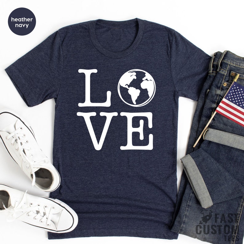 May include: A navy blue t-shirt with a white graphic of the word "LOVE" with a globe replacing the "O".