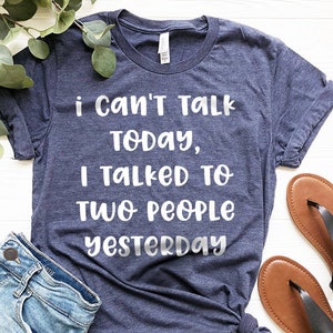 May include: A navy blue t-shirt with white text that reads "i can't talk today, i talked to two people yesterday".