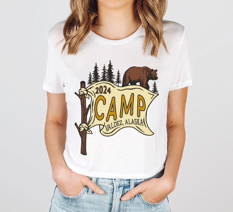 a woman wearing a white t - shirt with a brown bear on it