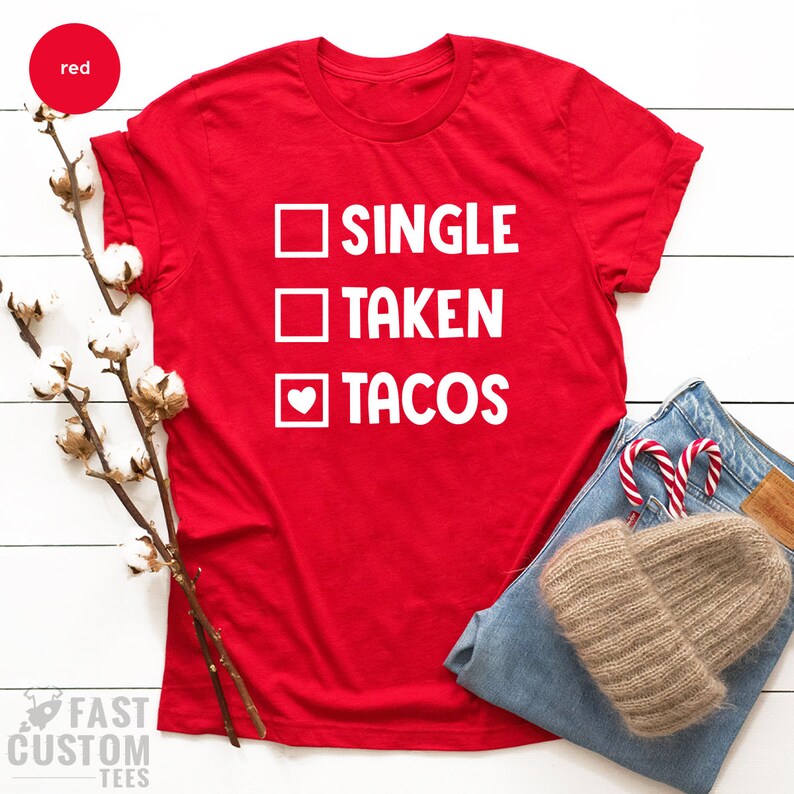 May include: Red t-shirt with white text that reads "SINGLE TAKEN TACOS" with a heart replacing the "O" in tacos.