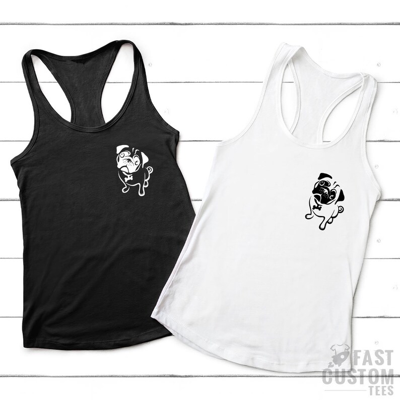 May include: Two racerback tank tops with a pug graphic on the front. The tank top on the left is black and the tank top on the right is white.