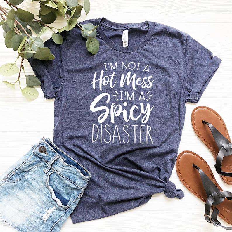 May include: A navy blue t-shirt with white text that reads "I'm not a hot mess I'm a spicy disaster".