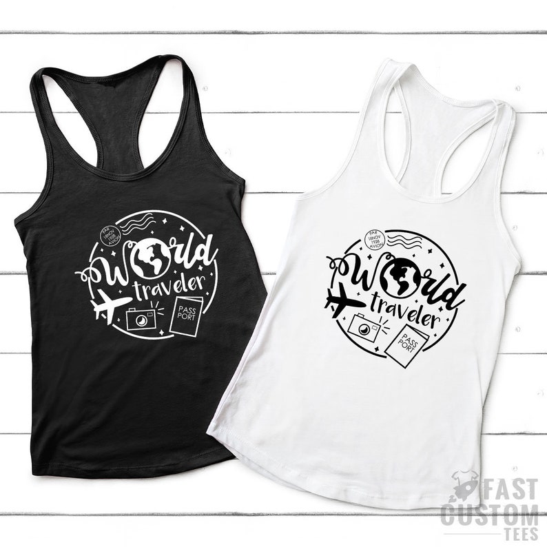 May include: Two tank tops with a white graphic design of a globe, airplane, camera, and passport with the text "World Traveler". One tank top is black and the other is white.