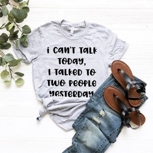May include: A gray t-shirt with the text "i can't talk today, i talked to two people yesterday" printed in black.