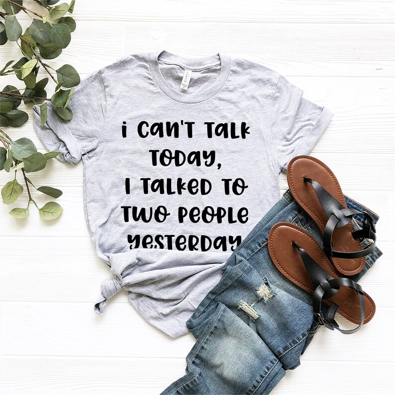 May include: A gray t-shirt with the text "i can't talk today, i talked to two people yesterday" printed in black.