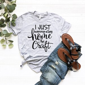 May include: A gray t-shirt with the text "I just wanna stay home and craft" in black lettering.