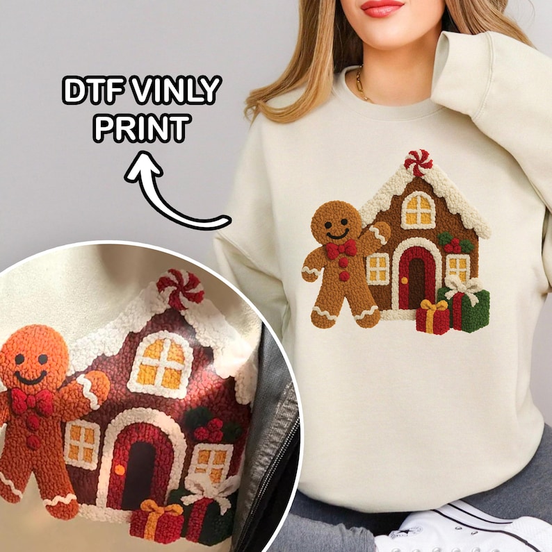 A woman wearing a white sweater with a detailed embroidered design of a gingerbread house and two gingerbread men.