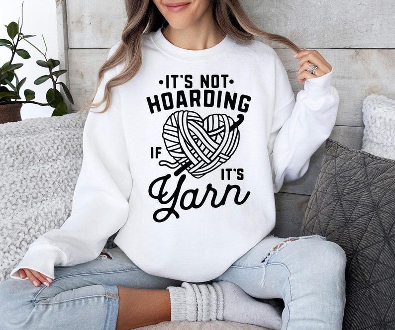 a woman sitting on a couch wearing a white sweater