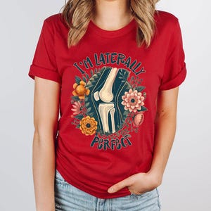 a woman wearing a red t - shirt with a picture of a woman's