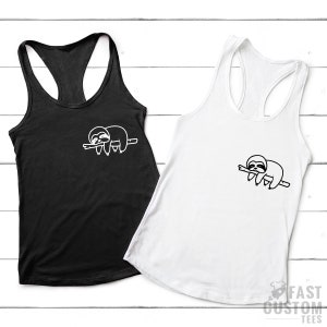K&ouml;nnte beinhalten: Zwei Tanktops mit einer wei&szlig;en Umrandung eines schlafenden Faultiers auf einem Ast. Das Tanktop links ist schwarz und das Tanktop rechts ist wei&szlig;.