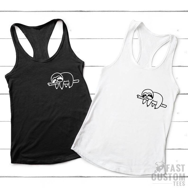 K&ouml;nnte beinhalten: Zwei Tanktops mit einer wei&szlig;en Umrandung eines schlafenden Faultiers auf einem Ast. Das Tanktop links ist schwarz und das Tanktop rechts ist wei&szlig;.