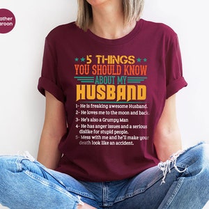 May include: A maroon t-shirt with a white graphic that says "5 THINGS YOU SHOULD KNOW ABOUT MY HUSBAND" and lists five things about a husband.