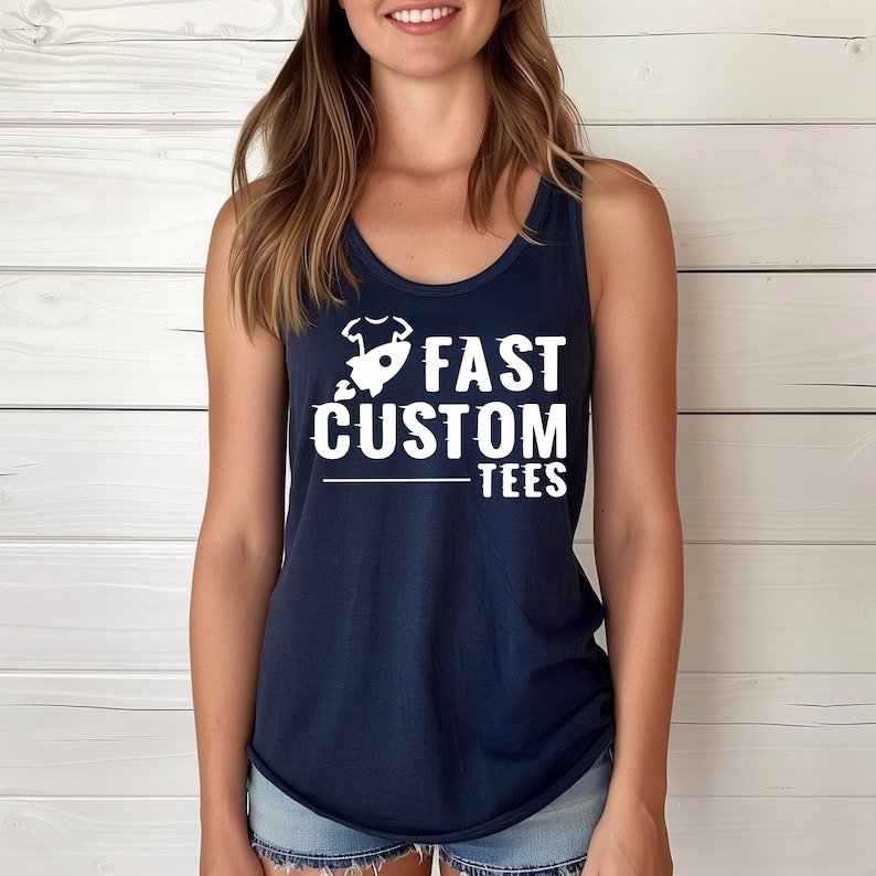 May include: A navy blue tank top with the words "FAST CUSTOM TEES" in large white letters. The text is accompanied by a small graphic. The tank top is sleeveless and has a scoop neck.