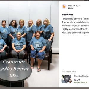 Może przedstawiać: Grupa kobiet w pasujących niebieskich koszulkach z okrągłym logo, pozujących do zdjęcia. Koszulki mają kr&oacute;tkie rękawy i okrągły dekolt. Tekst "Crossroads Ladies Retreat 2024" znajduje się na stole przed nimi.